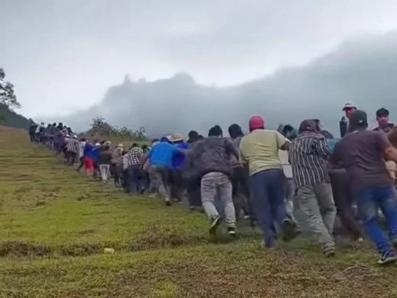 200 hombres cargan postes para restablecer luz en la Mixteca