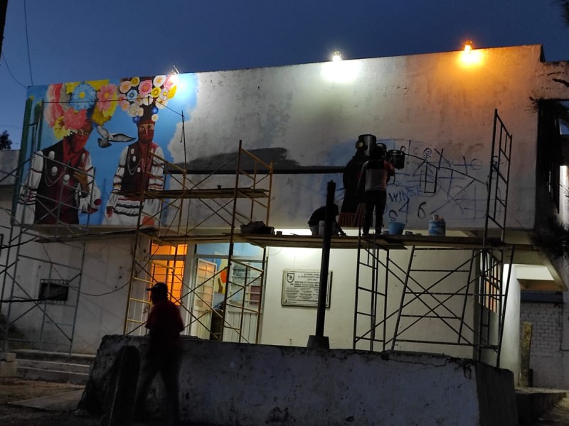 Artistas trabajan en mural en ex-estación del tren en Altepexi