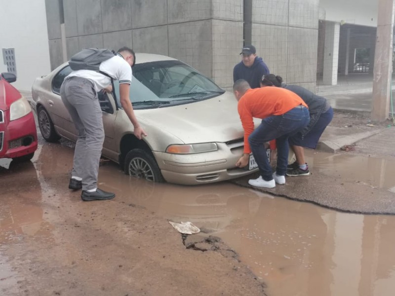 Auto queda atrapado en bache