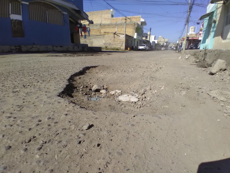 Baches causan constantes accidentes en calle Churubusco