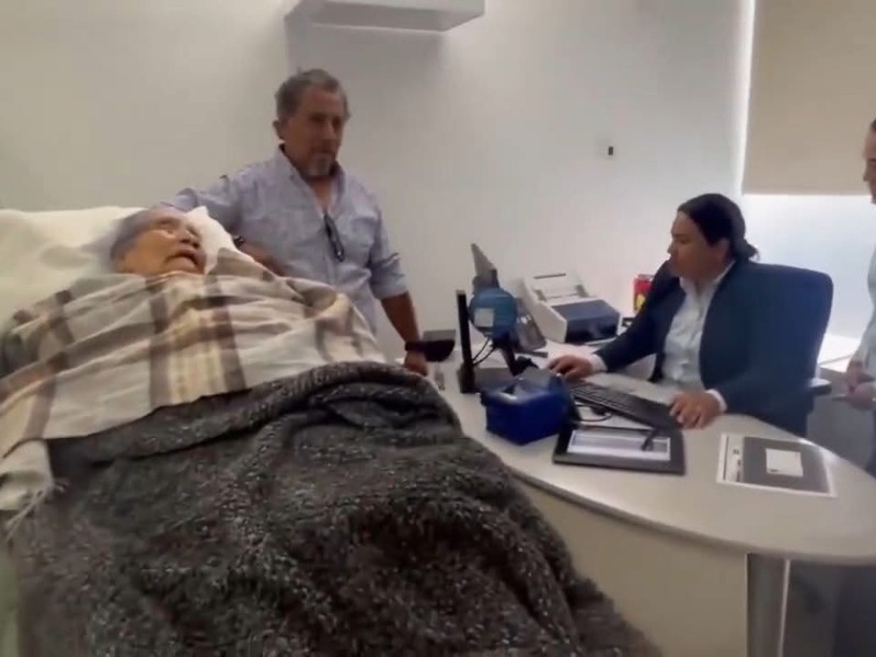 Banco obliga a adulta mayor en camilla a cobrar pensión