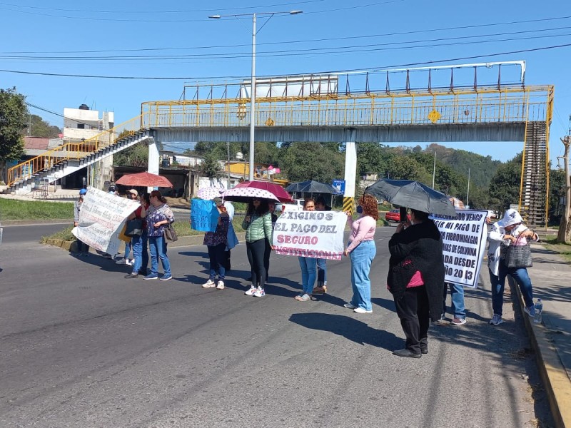 Bloquean bulevar Xalapa-Banderilla para exigir pago de seguros institucionales