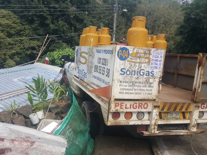 Camioneta del gas termina en techo de vivienda en Xalapa