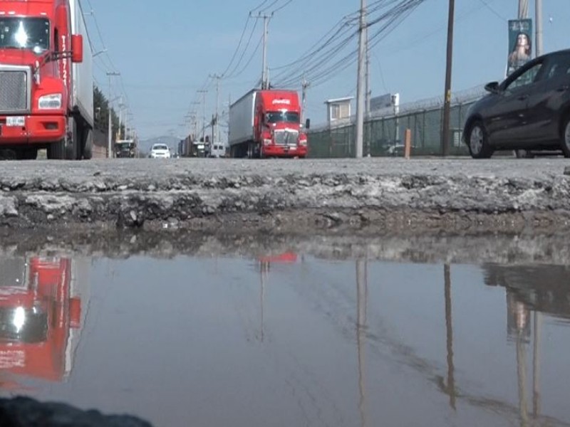 Choferes y trabajadores desafían baches a diario, zona industrial Toluca