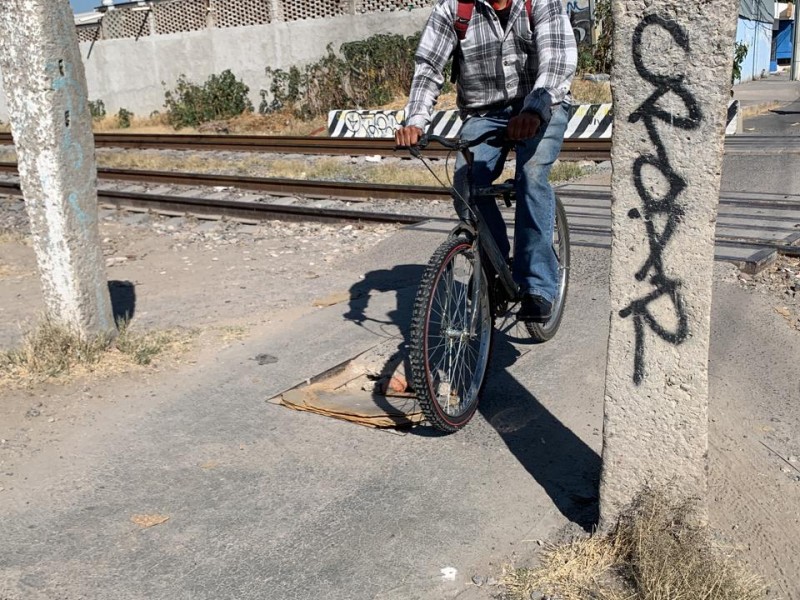 Ciclovía insegura y dañada en vías del tren.