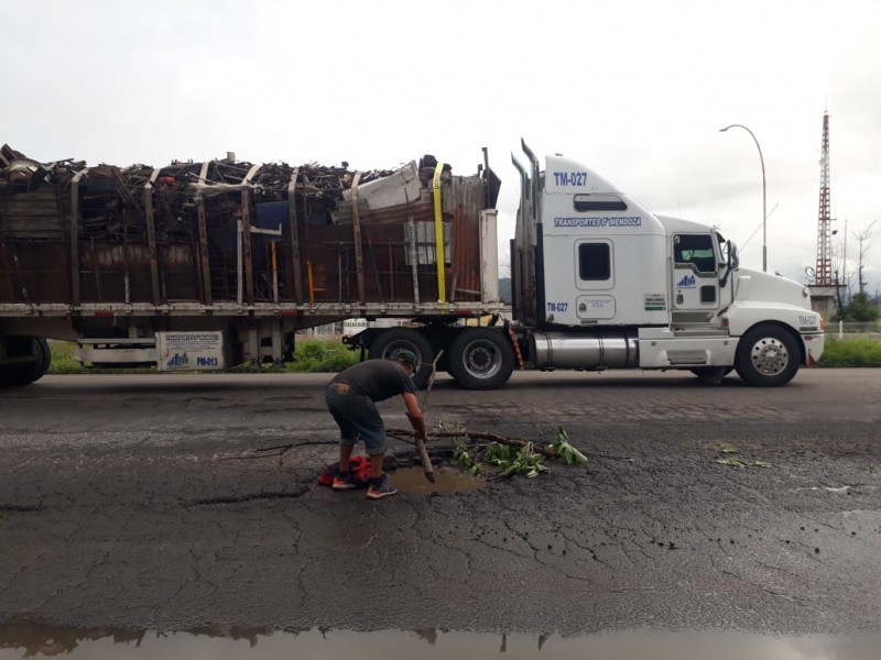 Ciudadano arriesga la vida por advertir sobre bache en libramiento