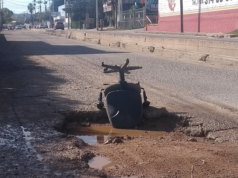 Colocan silla en bache para advertir a automovilistas