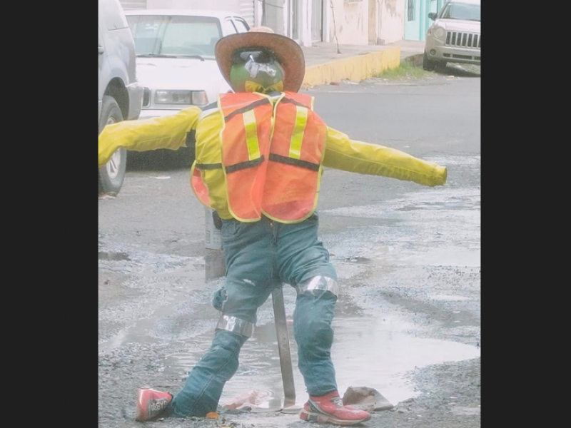 Con muñeco, señalizan bache en calle Ejido