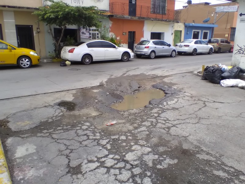 Denuncian bache y problema de basura en calle Rayón