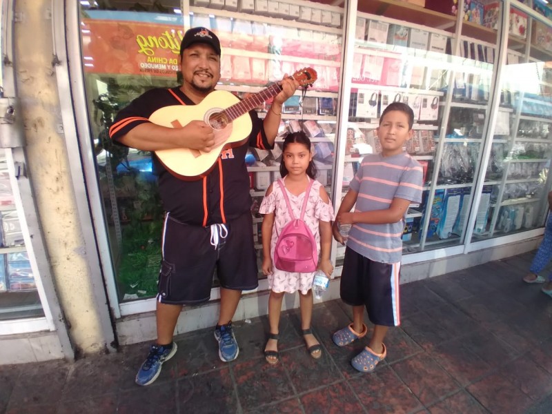 Dos hermanitos cantan para recaudar dinero y comprar útiles escolares