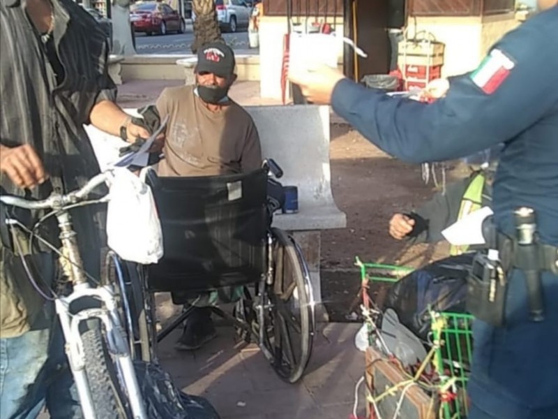 Elementos de la policía entregan volantes prevención Covid