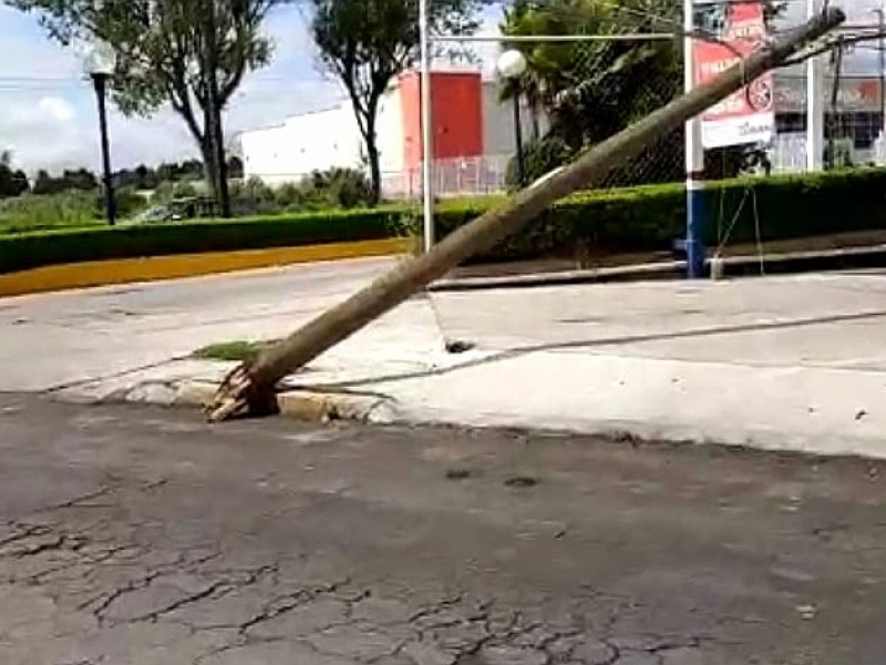 En riesgo peatones por un poste que está por caer