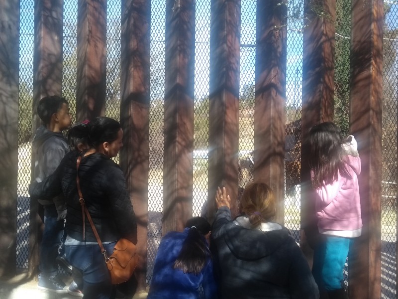 Familia se reúne a través de cerco fronterizo