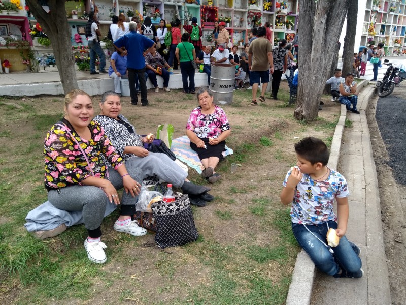 Familias comen en el panteón felices