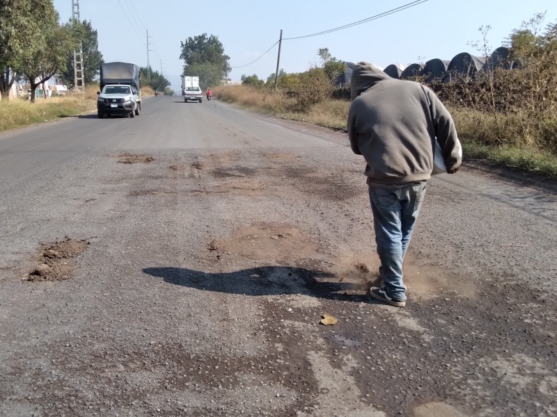 Jóvenes jaconenses tapan baches con tierra para evitar percances automovilísticos