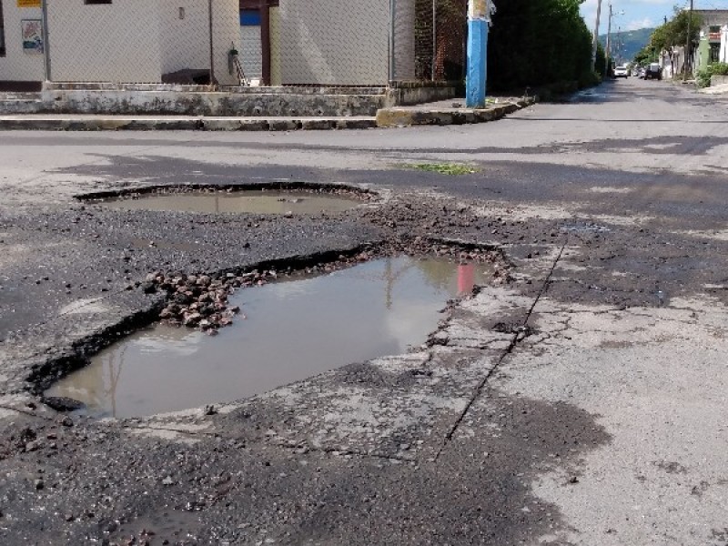 Lluvias continúan causando aparición de baches