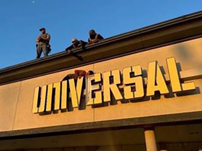 Migrante se queda atascado en letrero de negocio