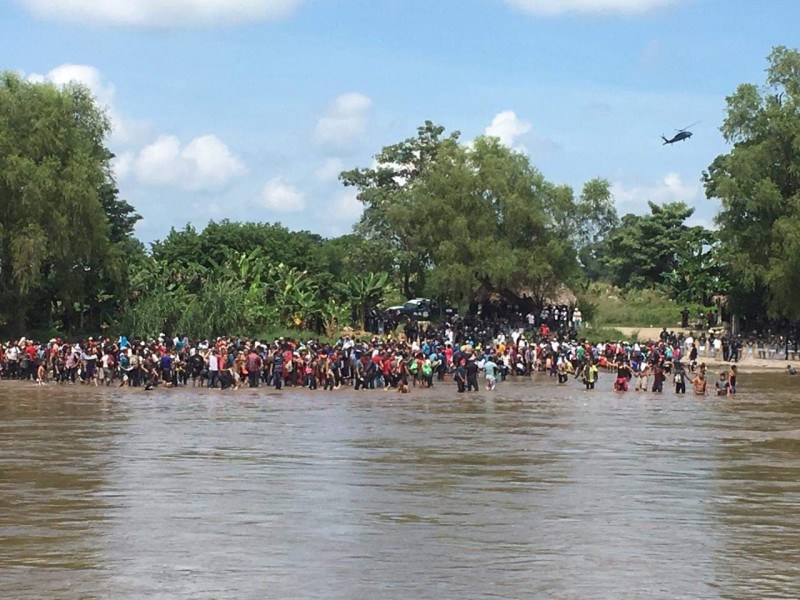 Migrantes cruzan nadando el río Suchiate
