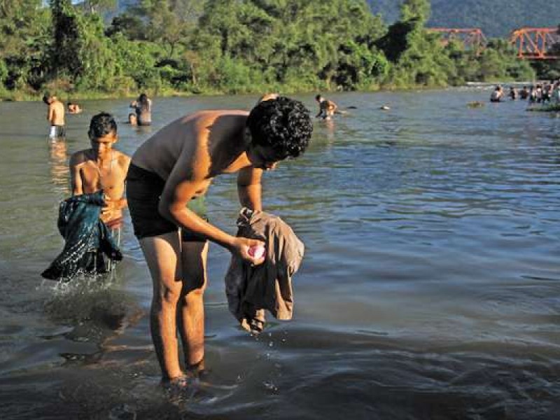 Migrantes permanecen a orillas del río Huixtla