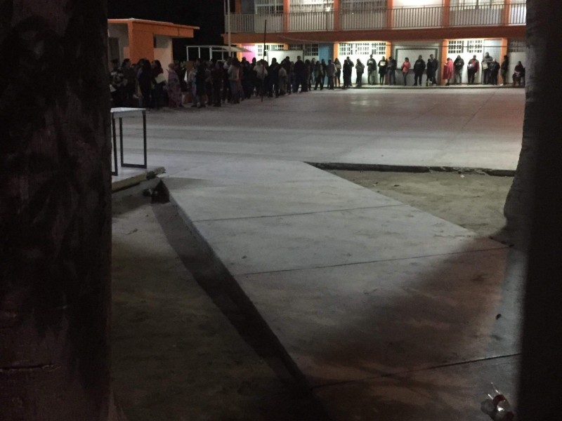 Padres hacen fila de noche para fichas de inscripción