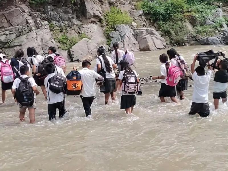 Piden puente vehicular en sierra de Totolapan; estudiantes cruzan río a pie