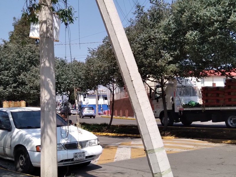 Poste a punto de caer en calle ceboruco en Metepec