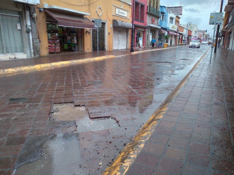 Reaparecen baches en adoquín del centro