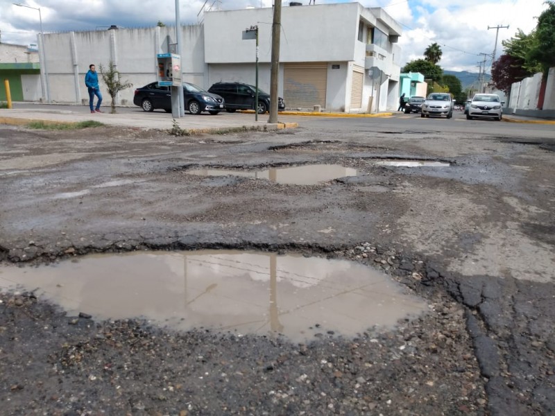 Reclaman vecinos por pavimento desecho en zona escolar