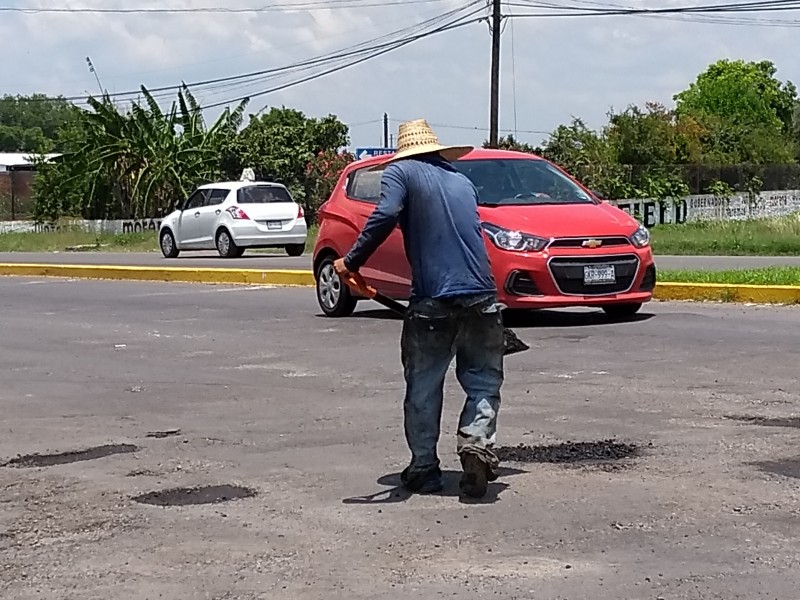 Reparan baches por monedas