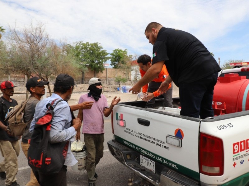 Reparte agua y suero oral a personas  en la vía pública