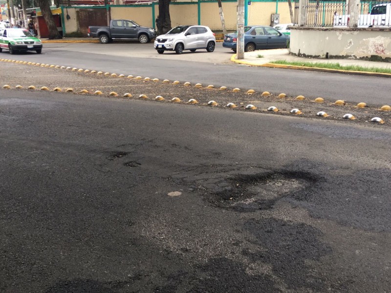 Reportan baches en avenida recien asfaltada