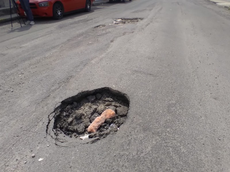 Se forma bache y socavón en calle Morelos