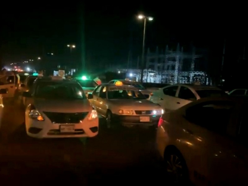 Se manifiestan taxistas bloqueando la carretera frente a seguridad pública