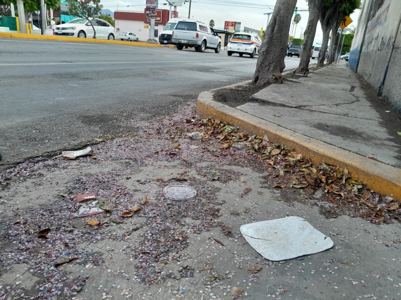 Calzada sucia por residuos de desfile y basura