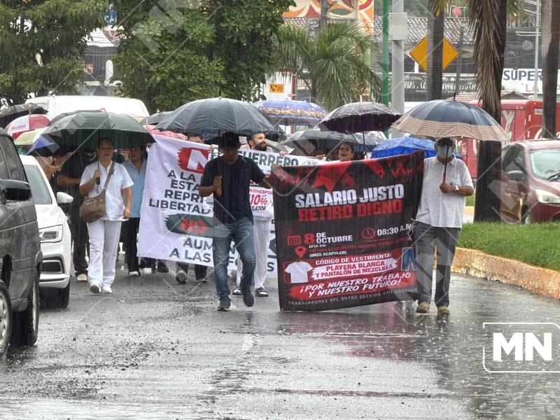 Trabajadores del Seguro Social marchan bajo la lluvia en Zihuatanejo