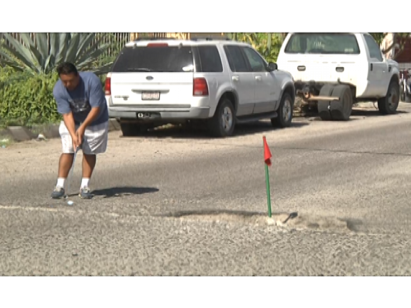 Utilizan los cientos de baches para jugar Golf