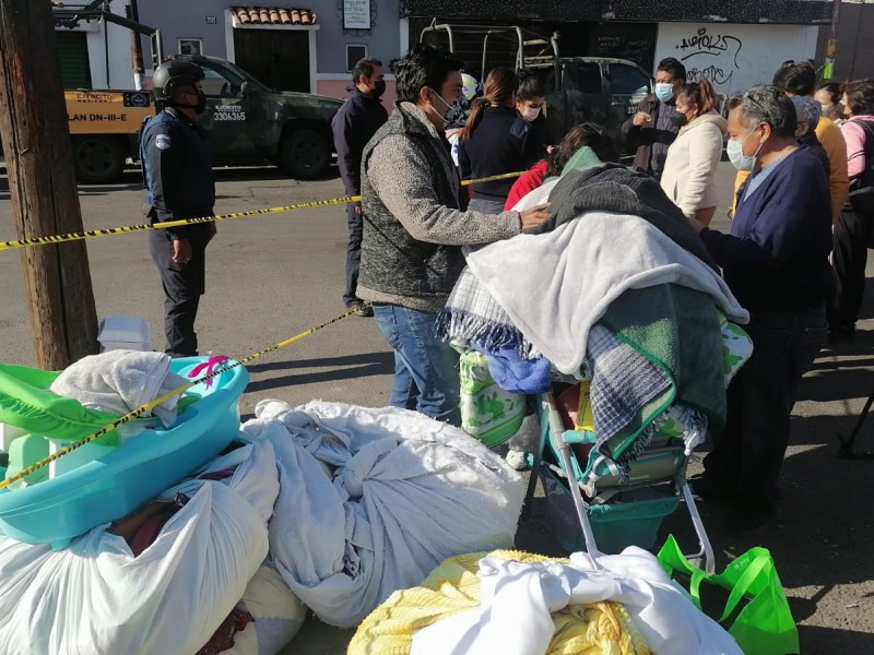 Vecinos afectados por la explosión sacan pertenencias de sus casas