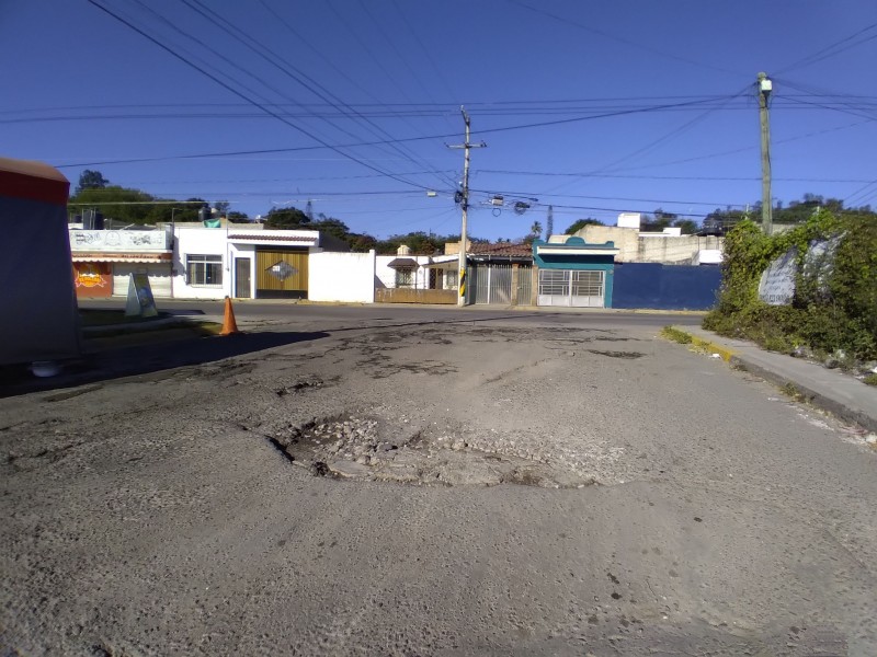 Vecinos colaboran para tapar baches en calle Helechos