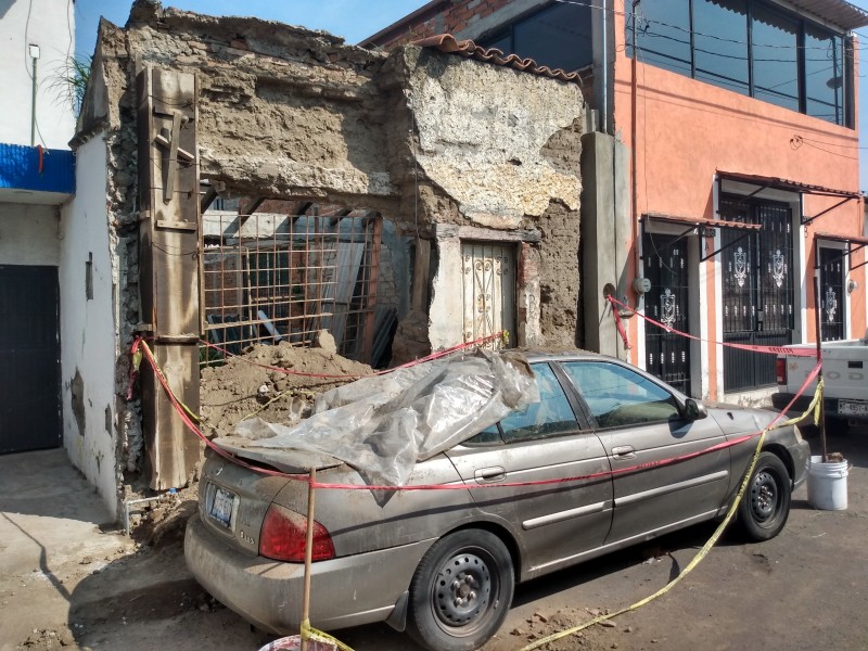 Vieja construcción cae sobre automóvil
